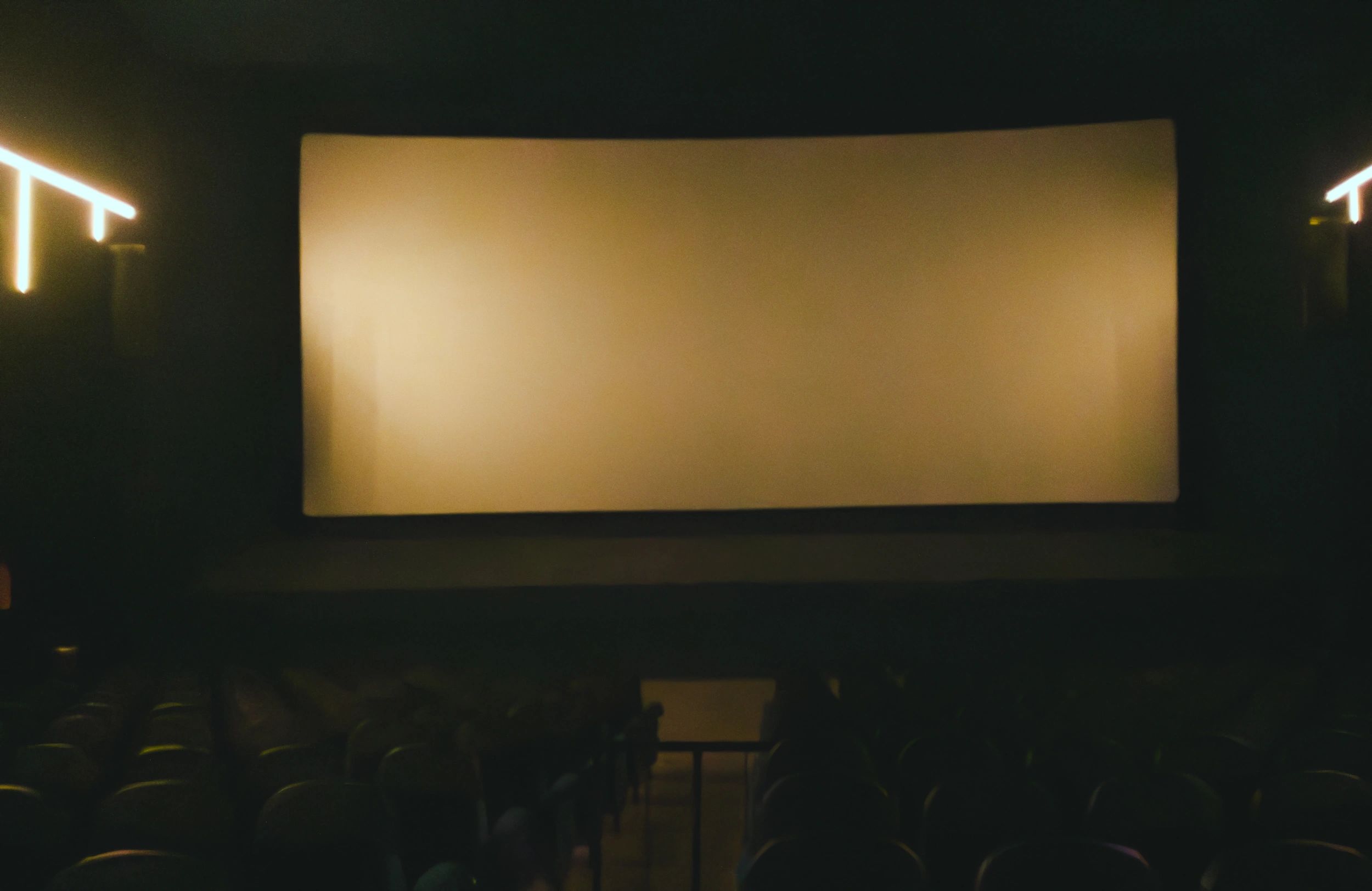 شاشة سينما كبيرة داخل قاعة مظلمة